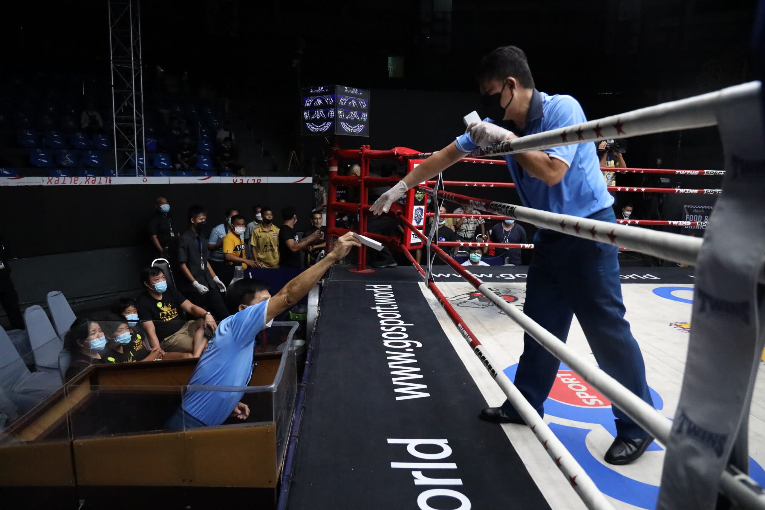 Muay Thai referees collecting the score cards from Judges. Photo by muaythaigram.net