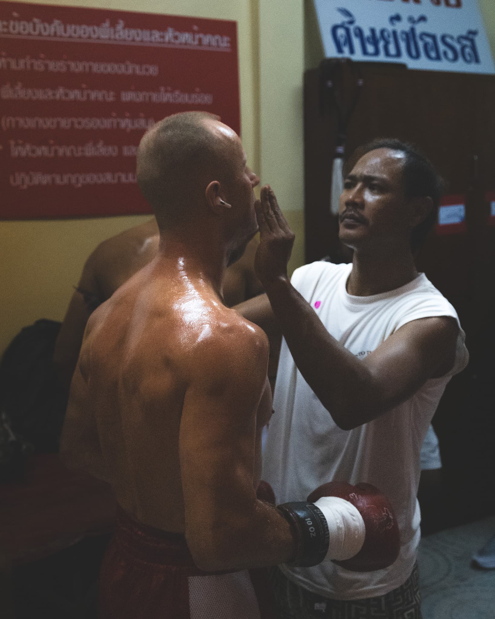 Trainer puts vaseline on his fighter in Phetchbuncha Stadium on Koh Samui